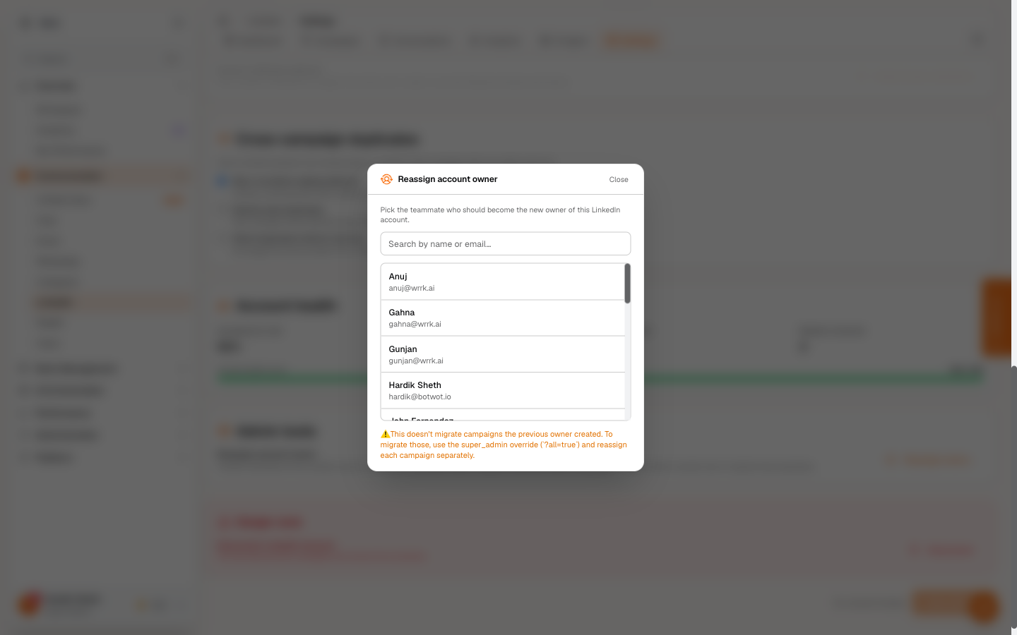 Reassign account owner modal — super_admin-only picker showing teammates by name + email, with a search box at the top and a yellow warning at the bottom noting that campaigns from the previous owner don't auto-migrate.